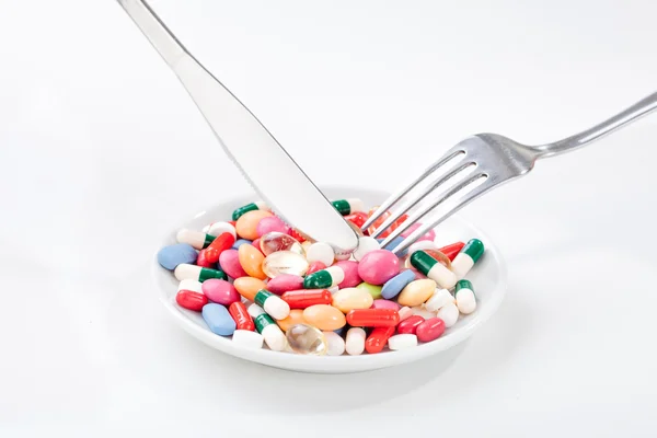 Drugs, medicine on a dish with fork, spoon — Stock Photo, Image