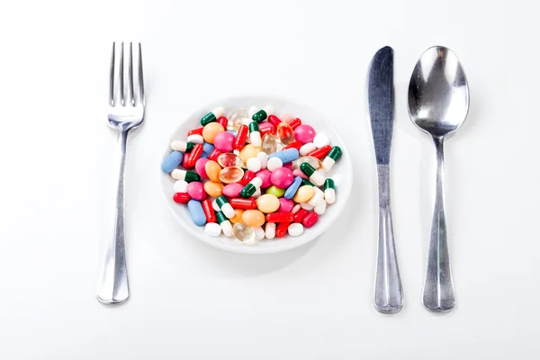 Medikamente, Medizin auf einem Teller mit Gabel, Löffel — Stockfoto