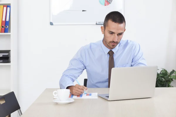 Hombre de negocios que trabaja en la oficina en su computadora portátil — Foto de Stock