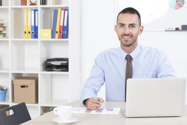 Молодий бізнесмен працює в офісі на своєму ноутбуці — стокове фото