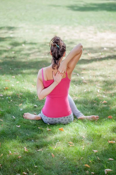 Junge Frau praktiziert Yoga im Park — Stockfoto