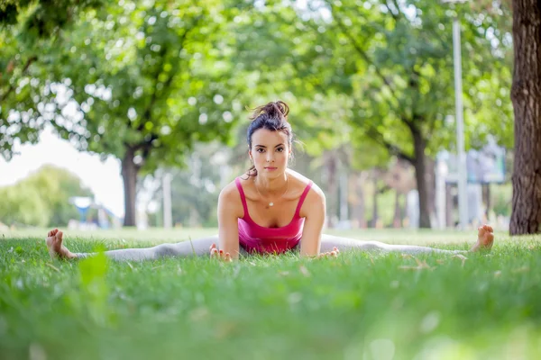 Genç kadın parkta yoga yapıyor. — Stok fotoğraf