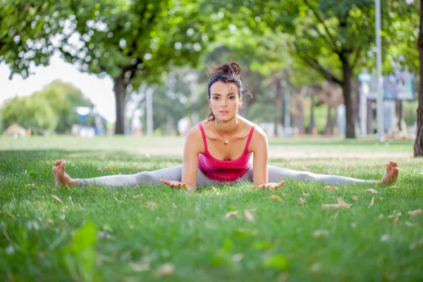 Genç kadın parkta yoga yapıyor. — Stok fotoğraf