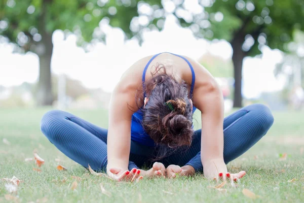 Mujer joven practicando yoga en el parque — Foto de Stock