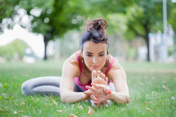 Genç kadın parkta yoga yapıyor. — Stok fotoğraf