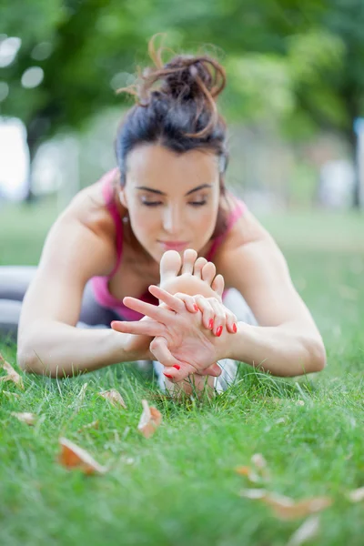 Junge Frau praktiziert Yoga im Park — Stockfoto