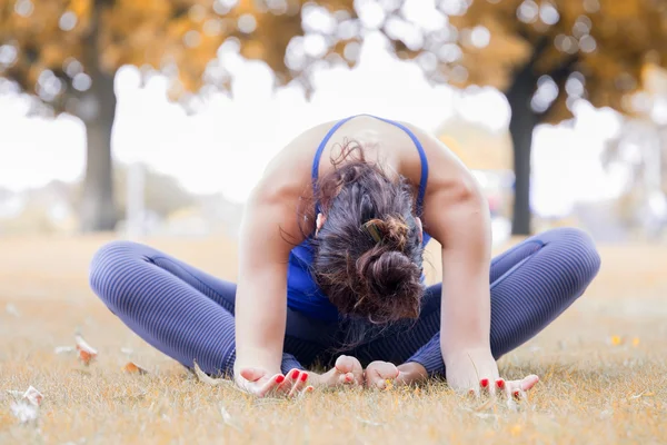 Junge Frau praktiziert Yoga im Park — Stockfoto