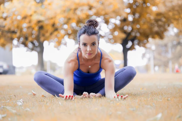 Genç kadın parkta yoga yapıyor. — Stok fotoğraf