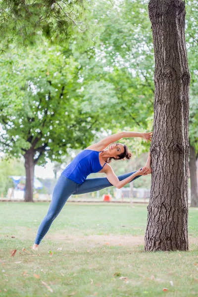 Genç kadın parkta yoga yapıyor. — Stok fotoğraf