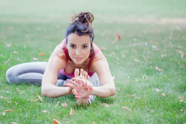 Mujer joven practicando yoga en el parque — Foto de Stock