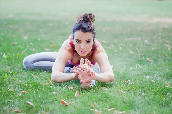 Genç kadın parkta yoga yapıyor. — Stok fotoğraf