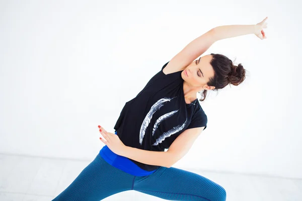 Mujer joven practicando yoga en estudio — Foto de Stock