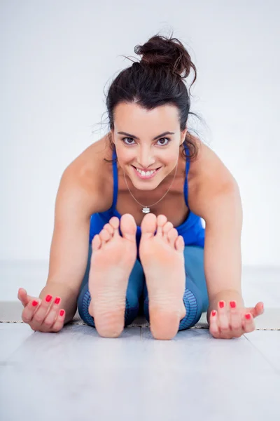 Mujer joven practicando yoga en estudio — Foto de Stock