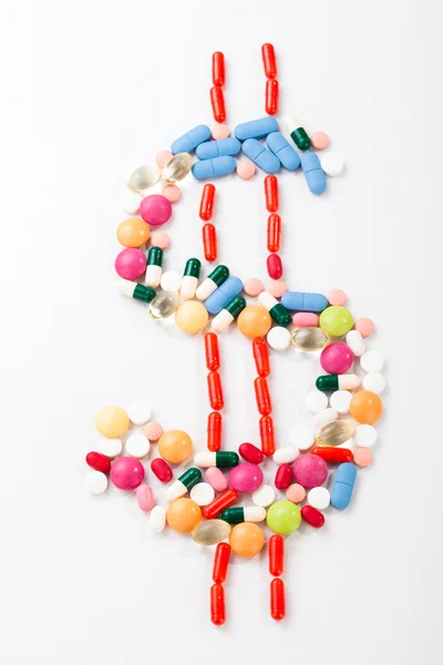 Pills and tablets on white background with dollar symbol in vivid color — Stock Photo, Image