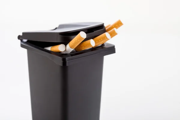 Bunch of cigarettes in the black trash can background. — Stock Photo, Image