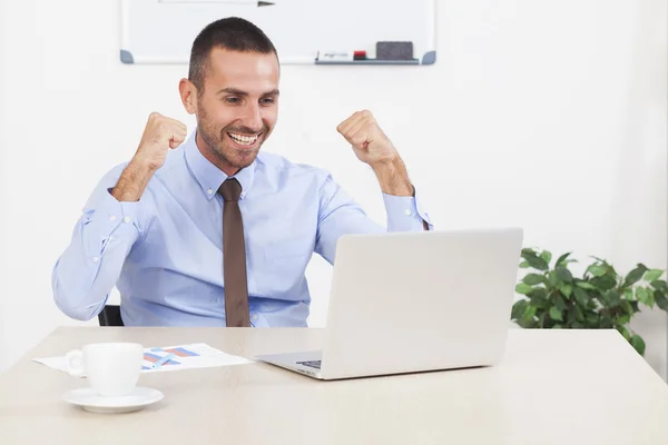 Boldog üzletember dolgozik az irodájában, a laptop — Stock Fotó