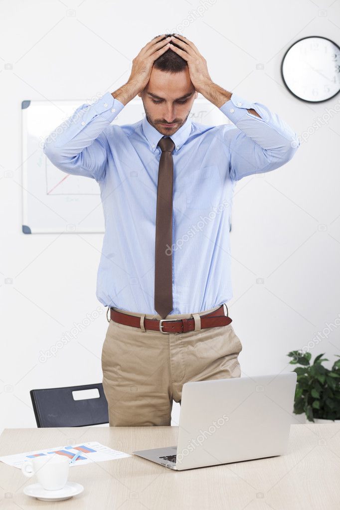 Stressed businessman working at his desk in his office