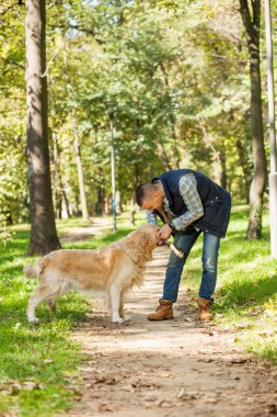 Genç adam bir köpek parkta yürüyüş
