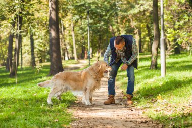 Genç adam bir köpek parkta yürüyüş