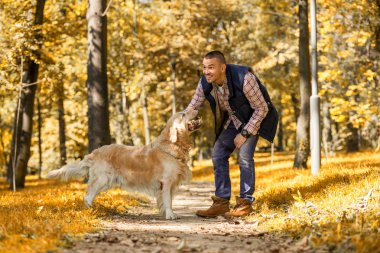 Genç adam bir köpek parkta yürüyüş