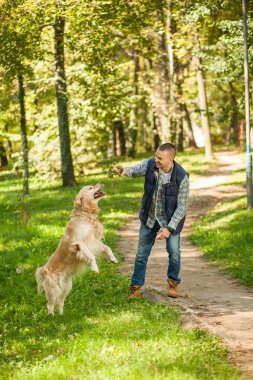 Genç adam bir köpek parkta yürüyüş