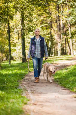 Genç adam bir köpek parkta yürüyüş