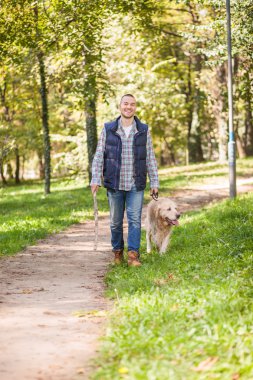 Genç adam bir köpek parkta yürüyüş