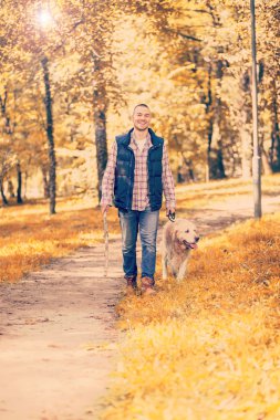 Genç adam bir köpek parkta yürüyüş