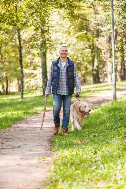 Genç adam bir köpek parkta yürüyüş