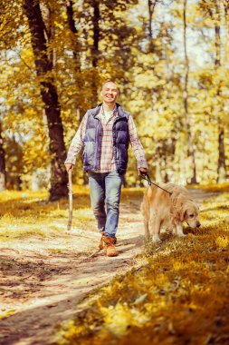 Genç adam bir köpek parkta yürüyüş