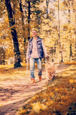 Genç adam bir köpek parkta yürüyüş