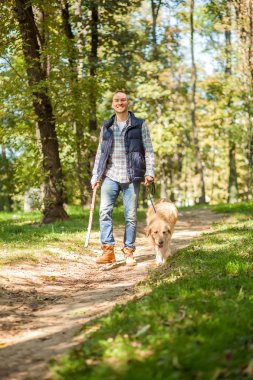 Genç adam bir köpek parkta yürüyüş