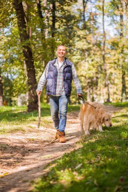 Genç adam bir köpek parkta yürüyüş