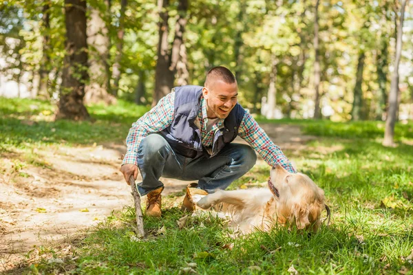 Молодой человек выгуливает собаку в парке — стоковое фото
