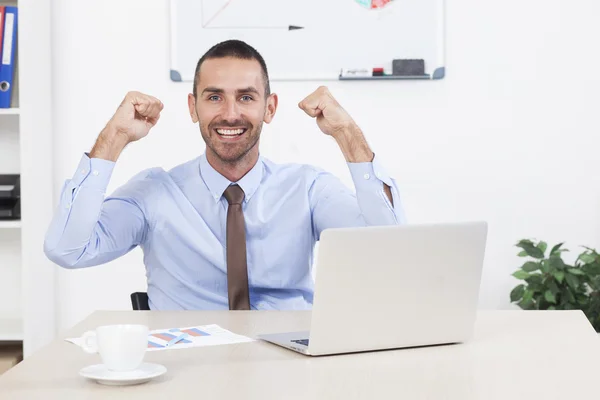 Щасливий бізнесмен працює в своєму офісі на ноутбуці — стокове фото