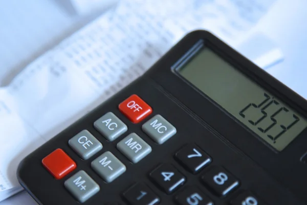 Ein Taschenrechner neben Finanzdokumenten — Stockfoto