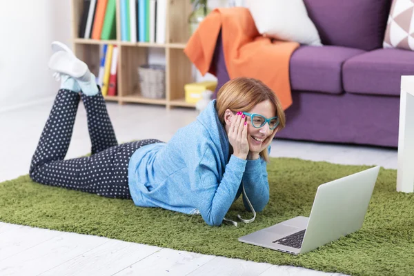 Donna sdraiata sul pavimento con computer portatile — Foto Stock