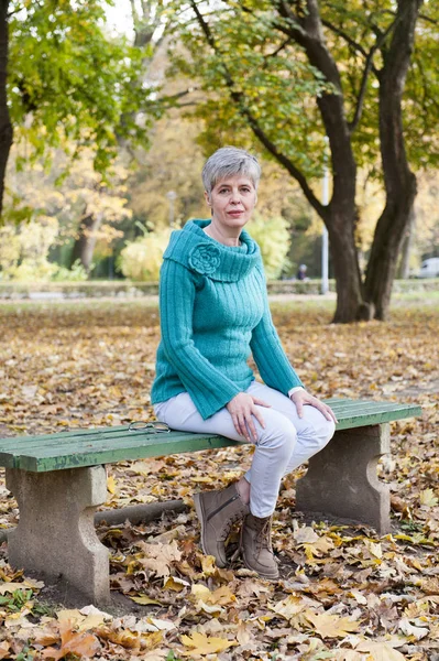 Sonbahar parkta orta yaşlı kadın — Stok fotoğraf