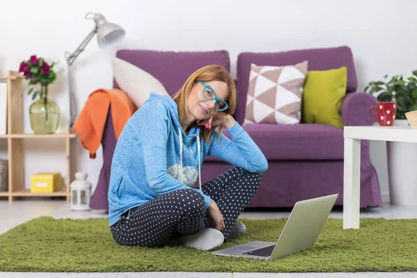 Vrouw in woonkamer met laptopcomputer — Stockfoto