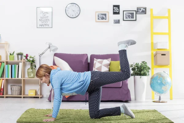 Женщина делает упражнения для тела в гостиной — стоковое фото