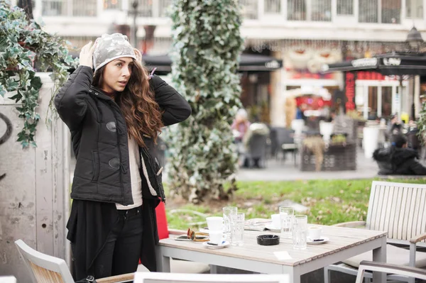 Jonge vrouw zetten een winter-hoed — Stockfoto