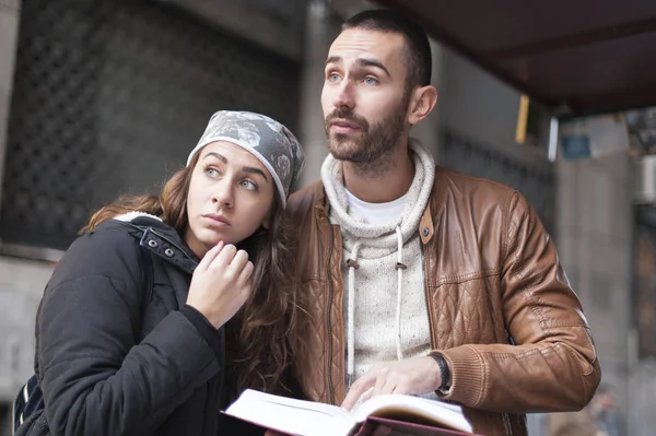 Homem confuso e uma menina com um livro guia da cidade — Fotografia de Stock