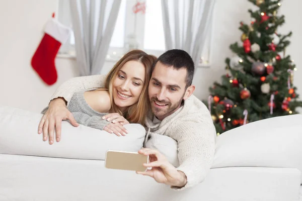 Casal apaixonado tomando selfie na noite de Natal — Fotografia de Stock