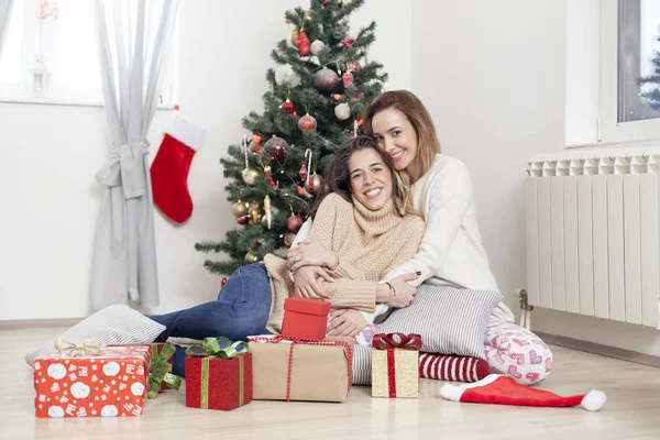 Women next to Christmas tree with Christmas presents — Stock Photo, Image