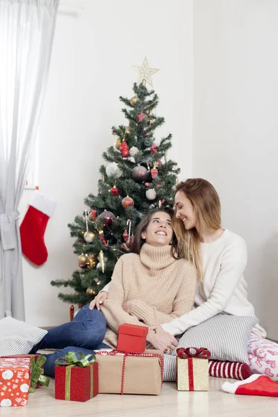 Mulheres ao lado da árvore de Natal com presentes de Natal — Fotografia de Stock