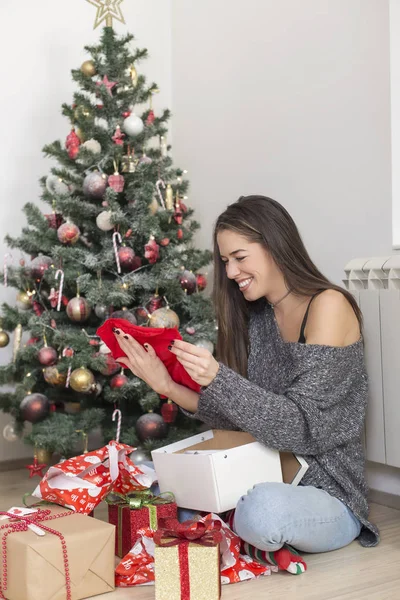 Nő mellett karácsonyfa megnyitása bemutatja — Stock Fotó
