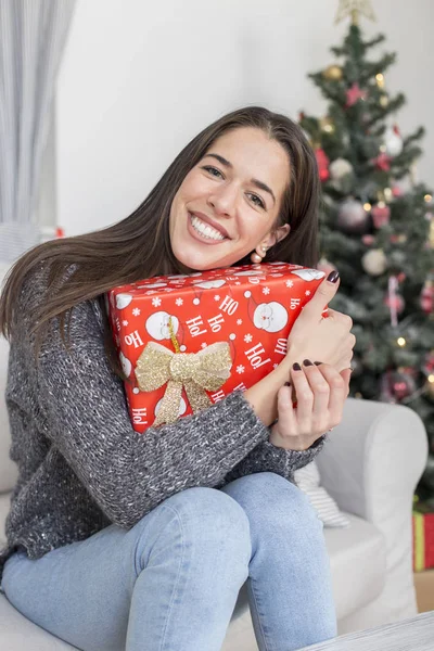 Donna accanto all'albero di Natale con un regalo — Foto Stock