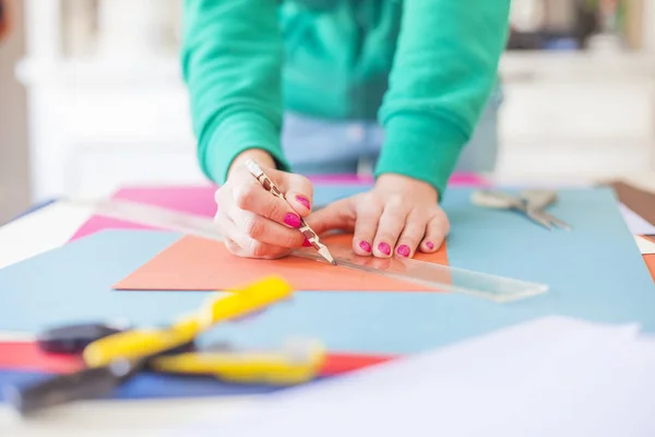 Vrouw maken scrapbook van de papieren op tafel — Stockfoto