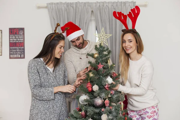 Friends and family decorating Christmas tree