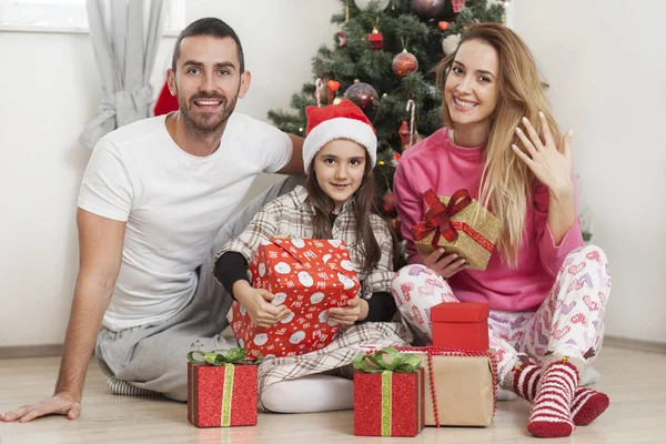 Famiglia davanti all'albero di Natale apertura regali — Foto Stock